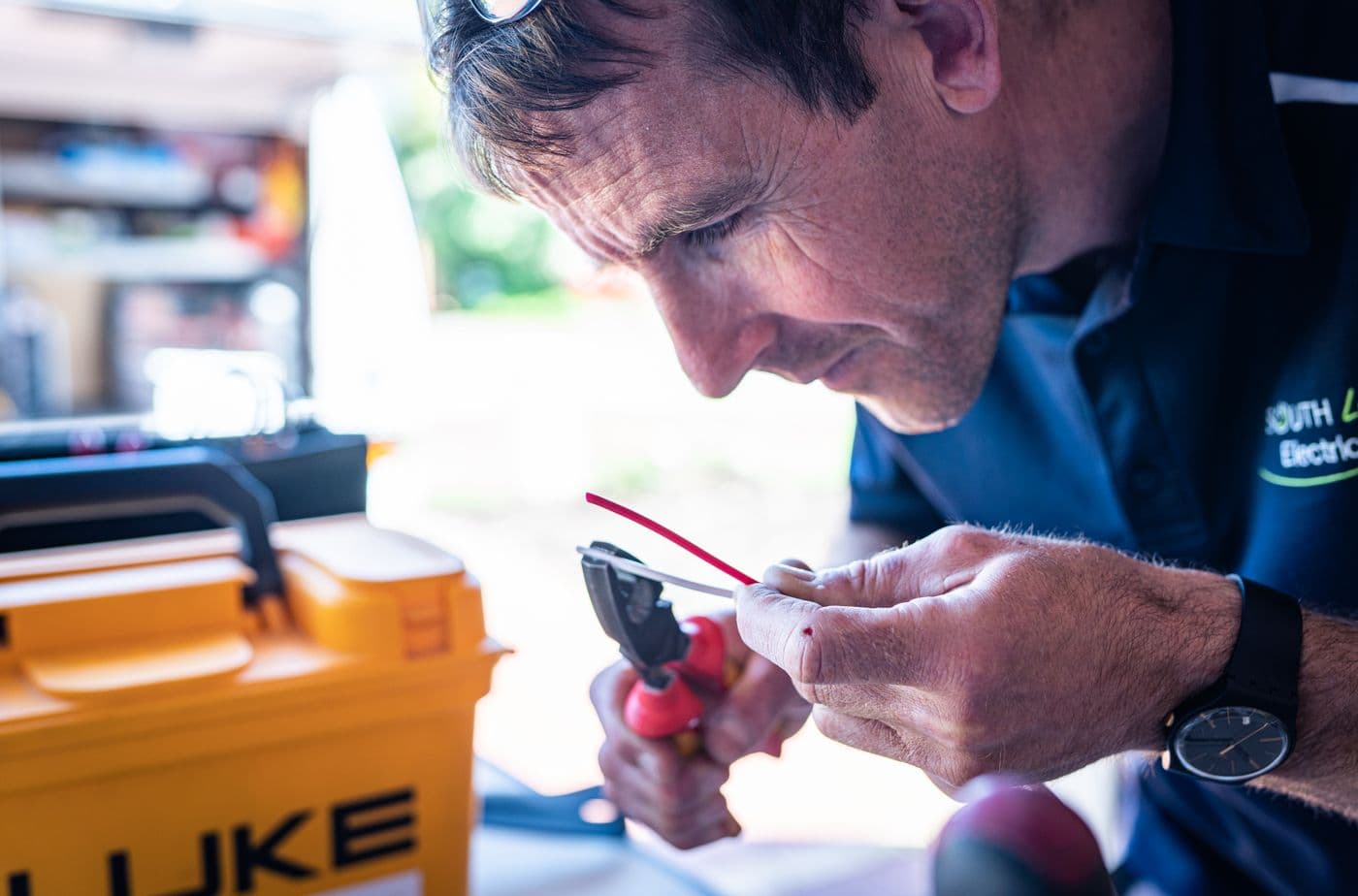 Electrician working with hand tools on an electrical repair