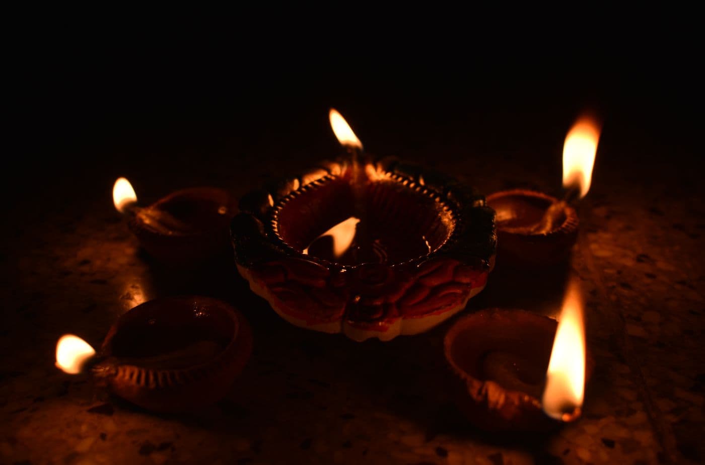 Traditional oil lamps lit in a row for a festival celebration