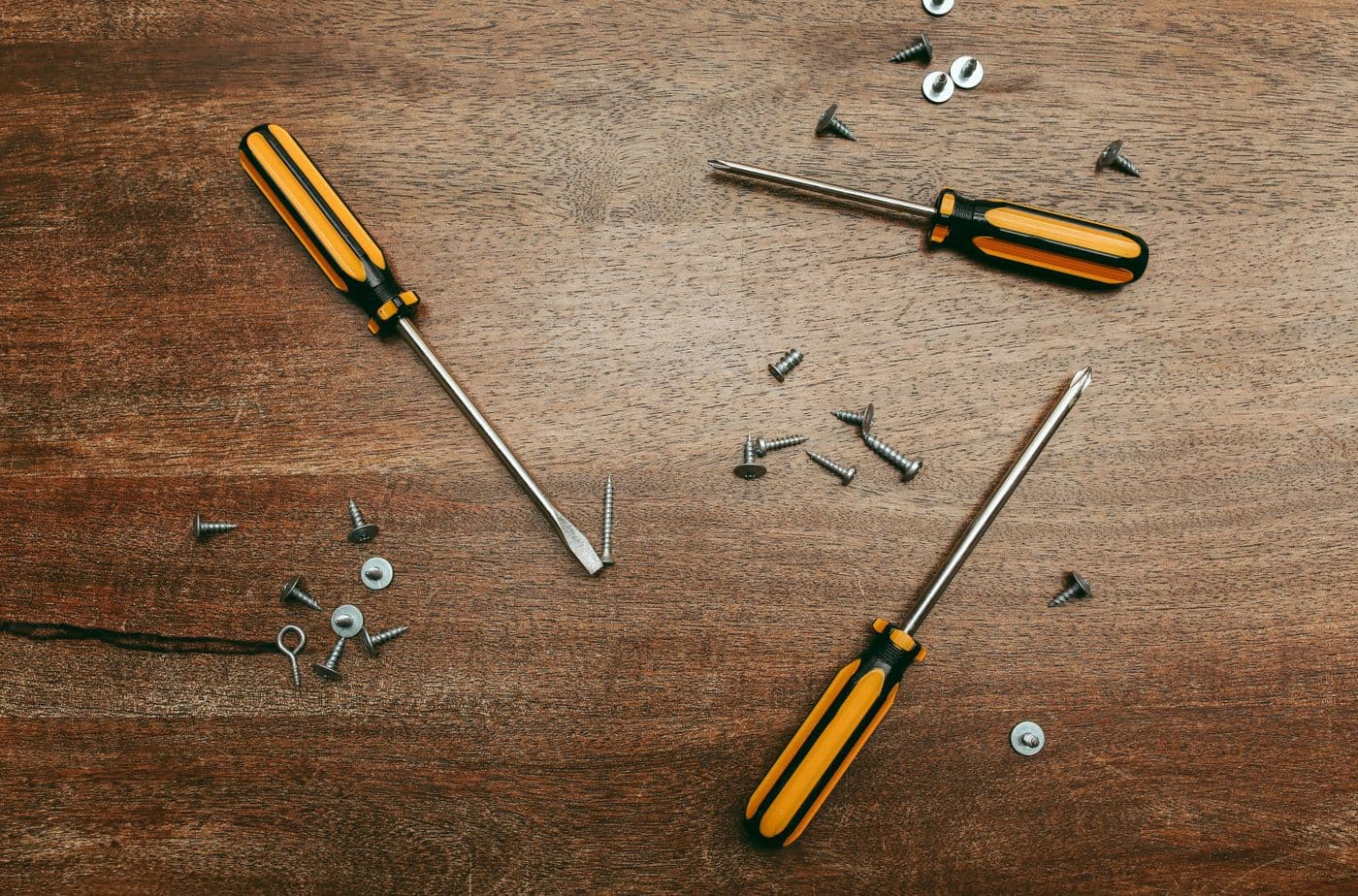 Set of screwdrivers and hand tools laid out on a wooden surface