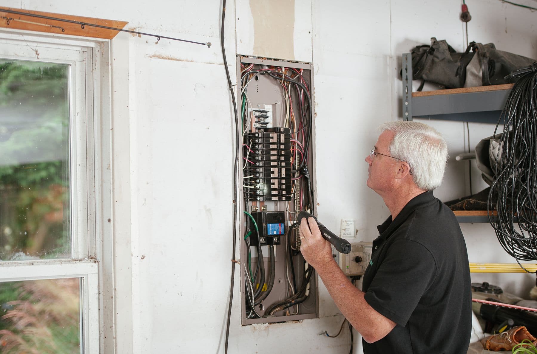 Wire Men electrician working on an open distribution board inside a Surat home