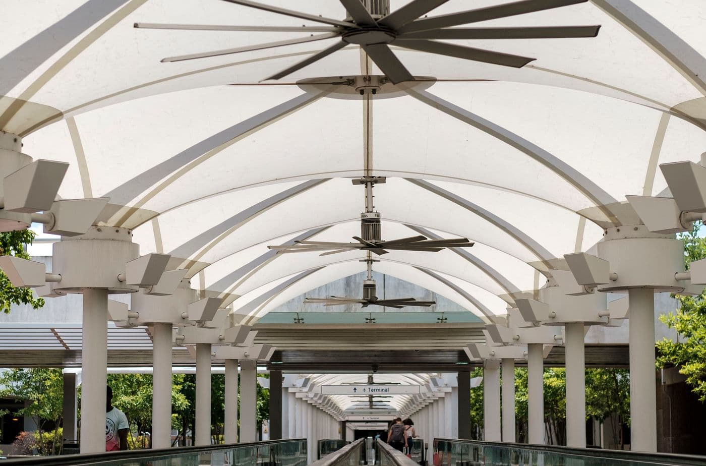 Row of ceiling fans installed in a bright open hall
