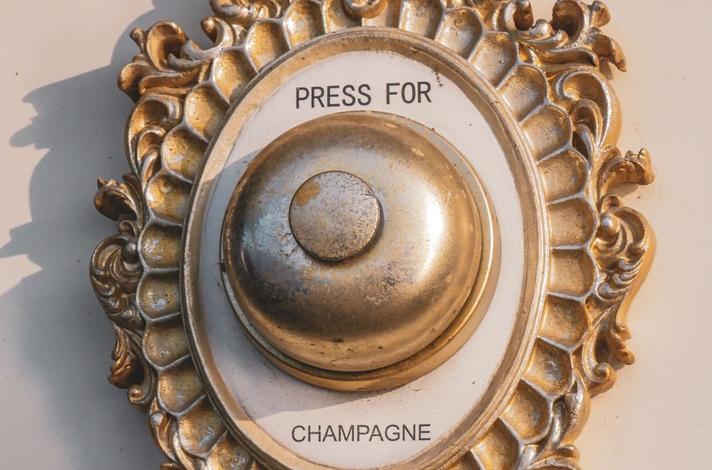 Traditional brass doorbell push fitted beside an entrance door