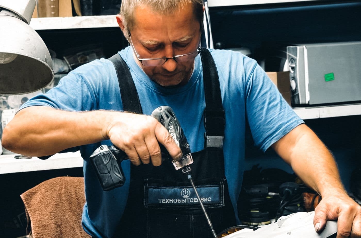 Electrician working at a bench on electrical equipment